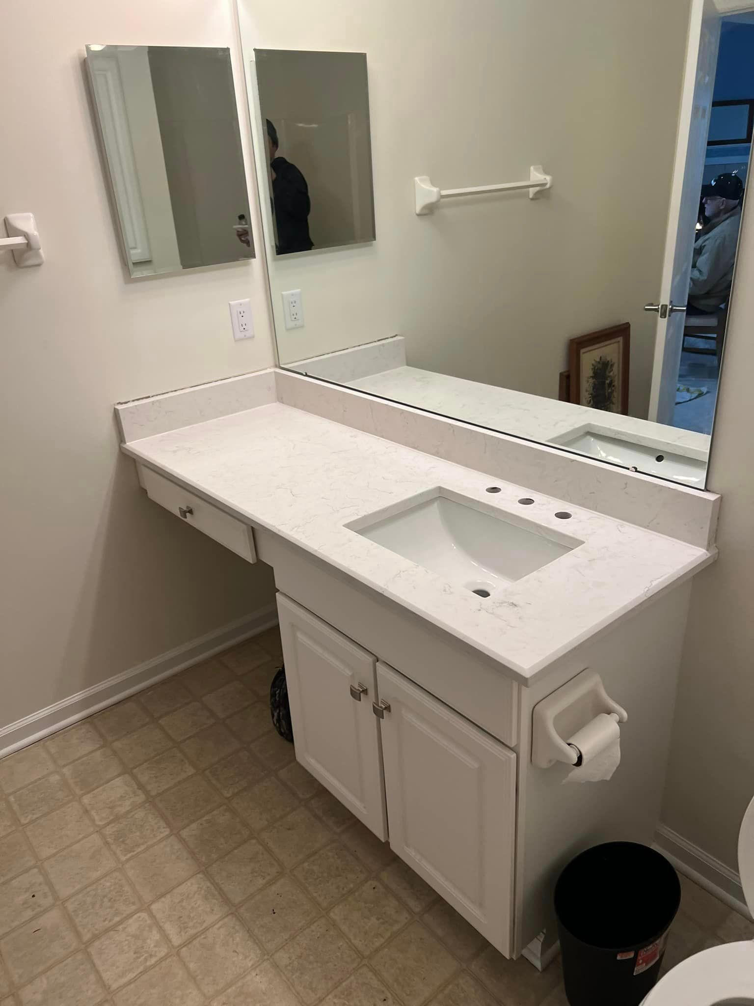 A bathroom with a sink , mirror and toilet.