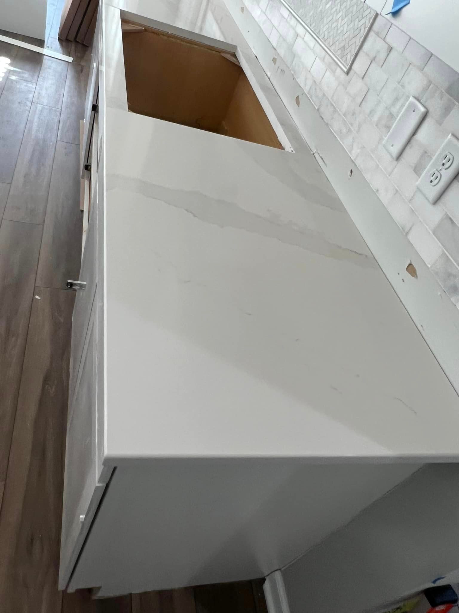 A white counter top with a sink in a kitchen.