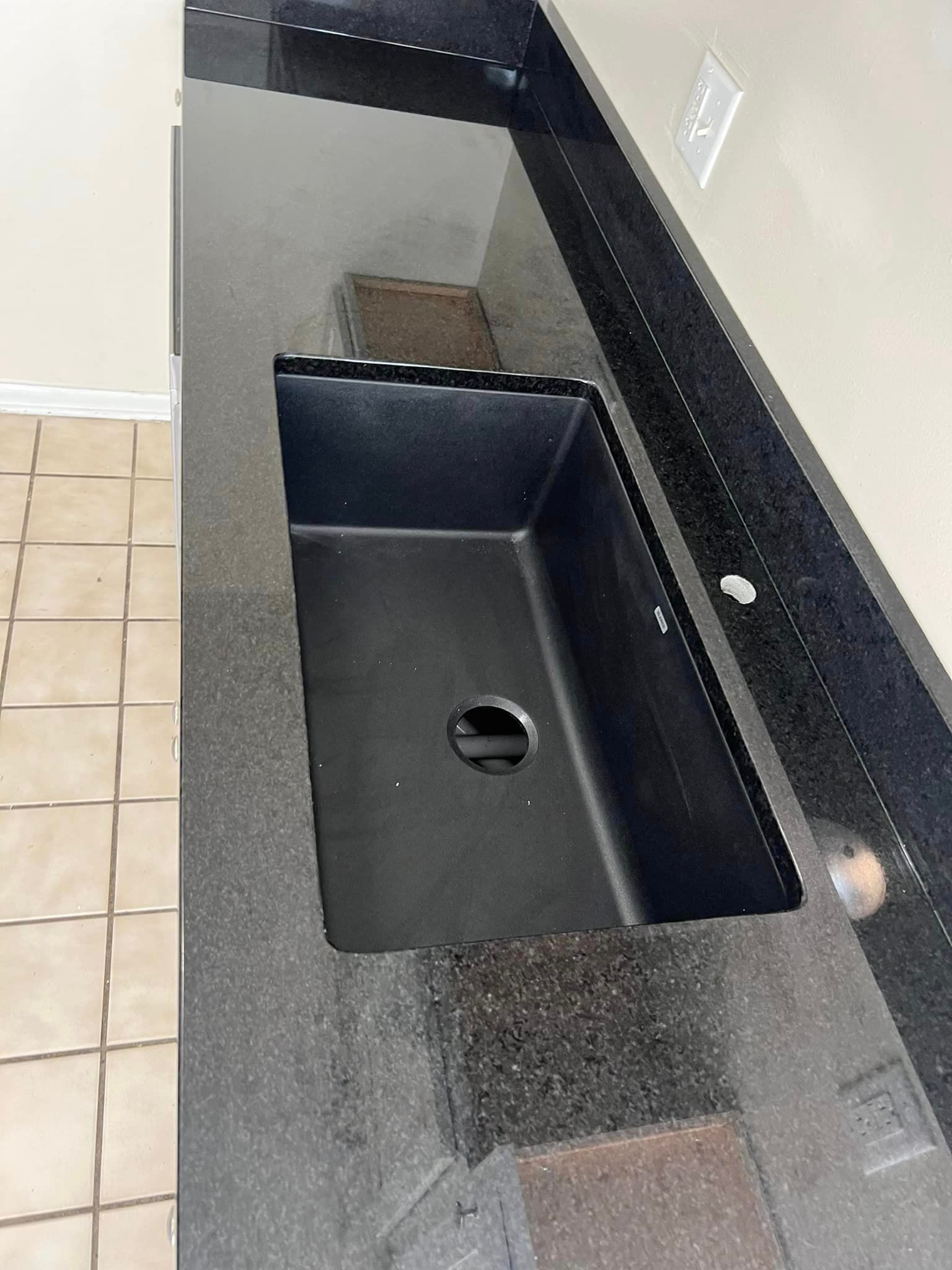 A black sink is sitting on top of a black counter top.