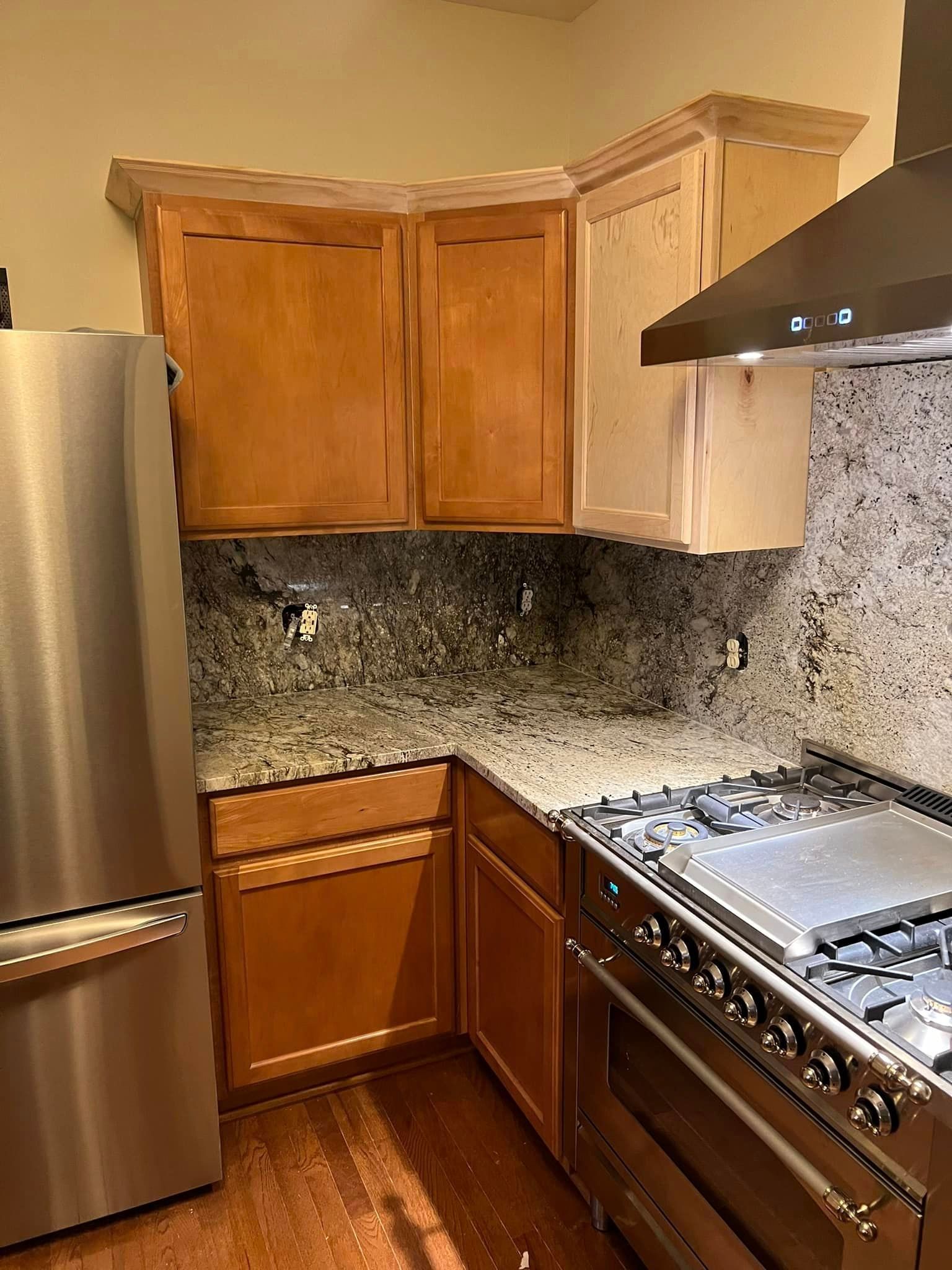 A kitchen with stainless steel appliances and wooden cabinets.