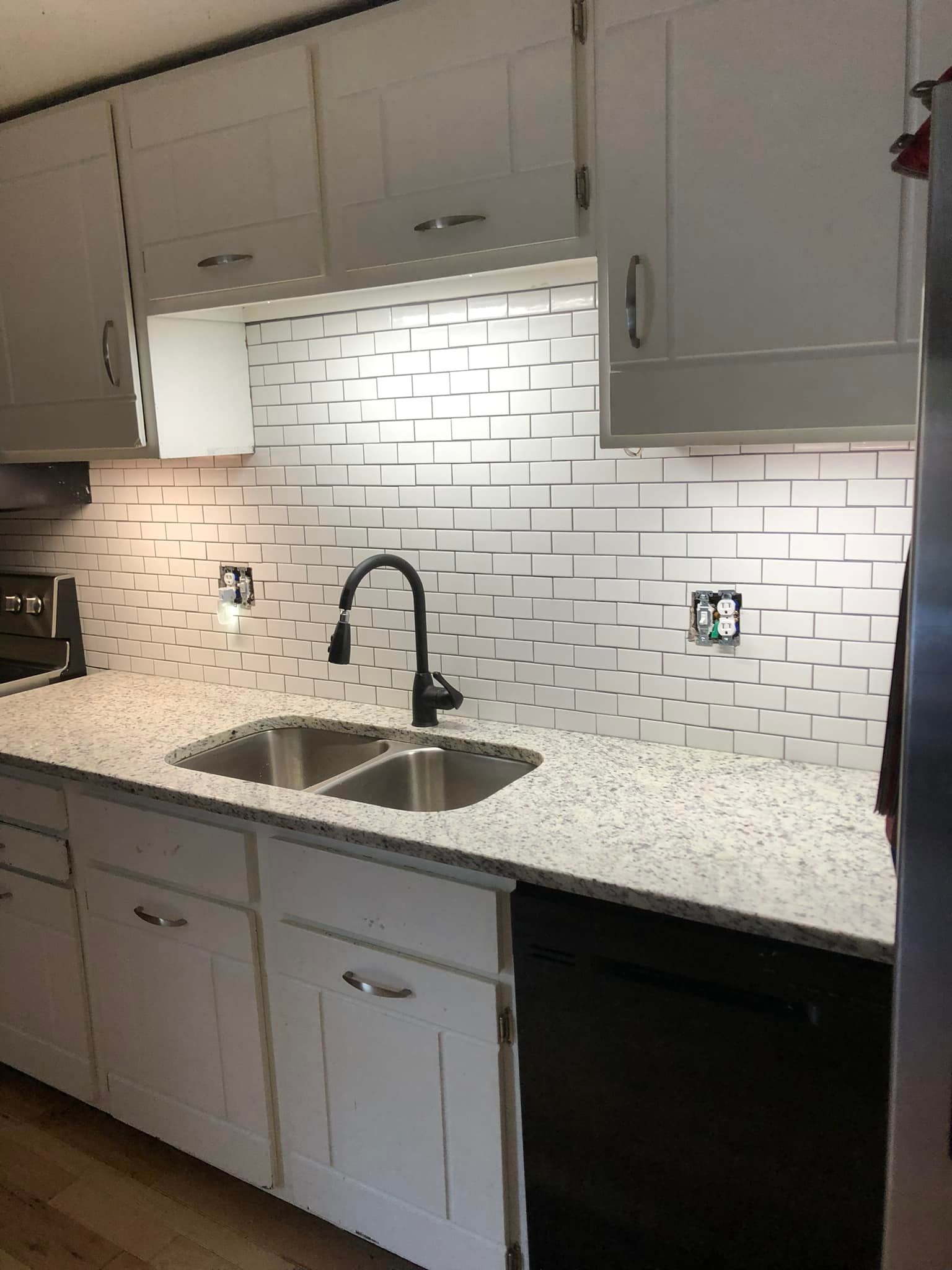 A kitchen with white cabinets and granite counter tops