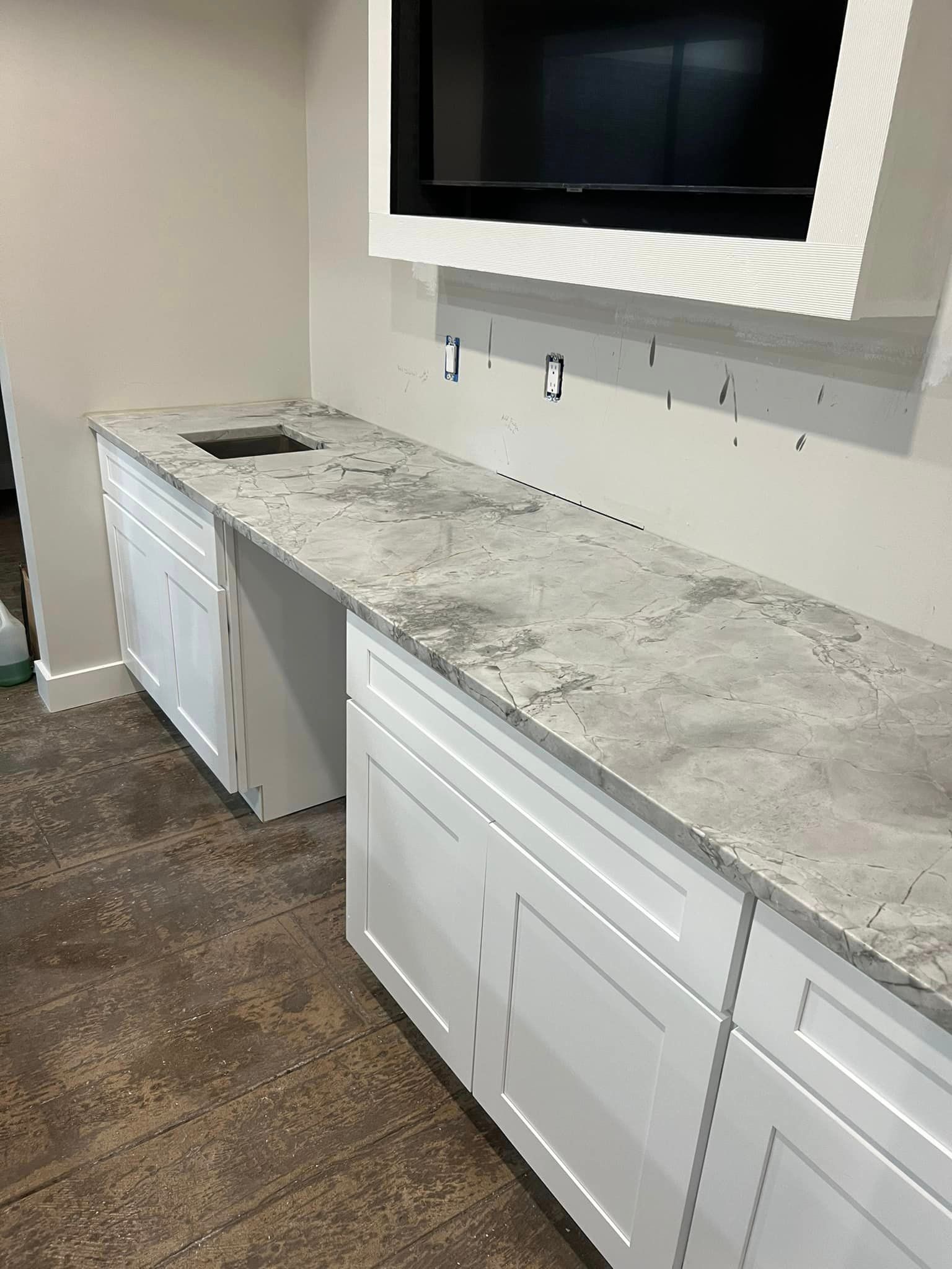 A kitchen with white cabinets and granite counter tops.