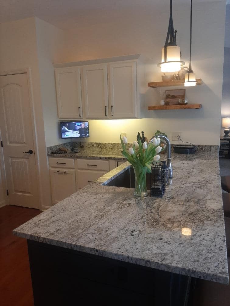 A kitchen with a granite counter top and a sink.