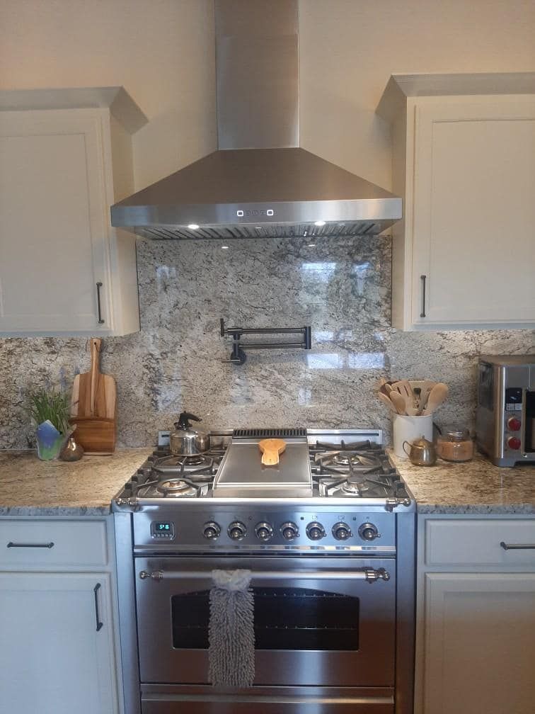 A kitchen with stainless steel appliances and white cabinets