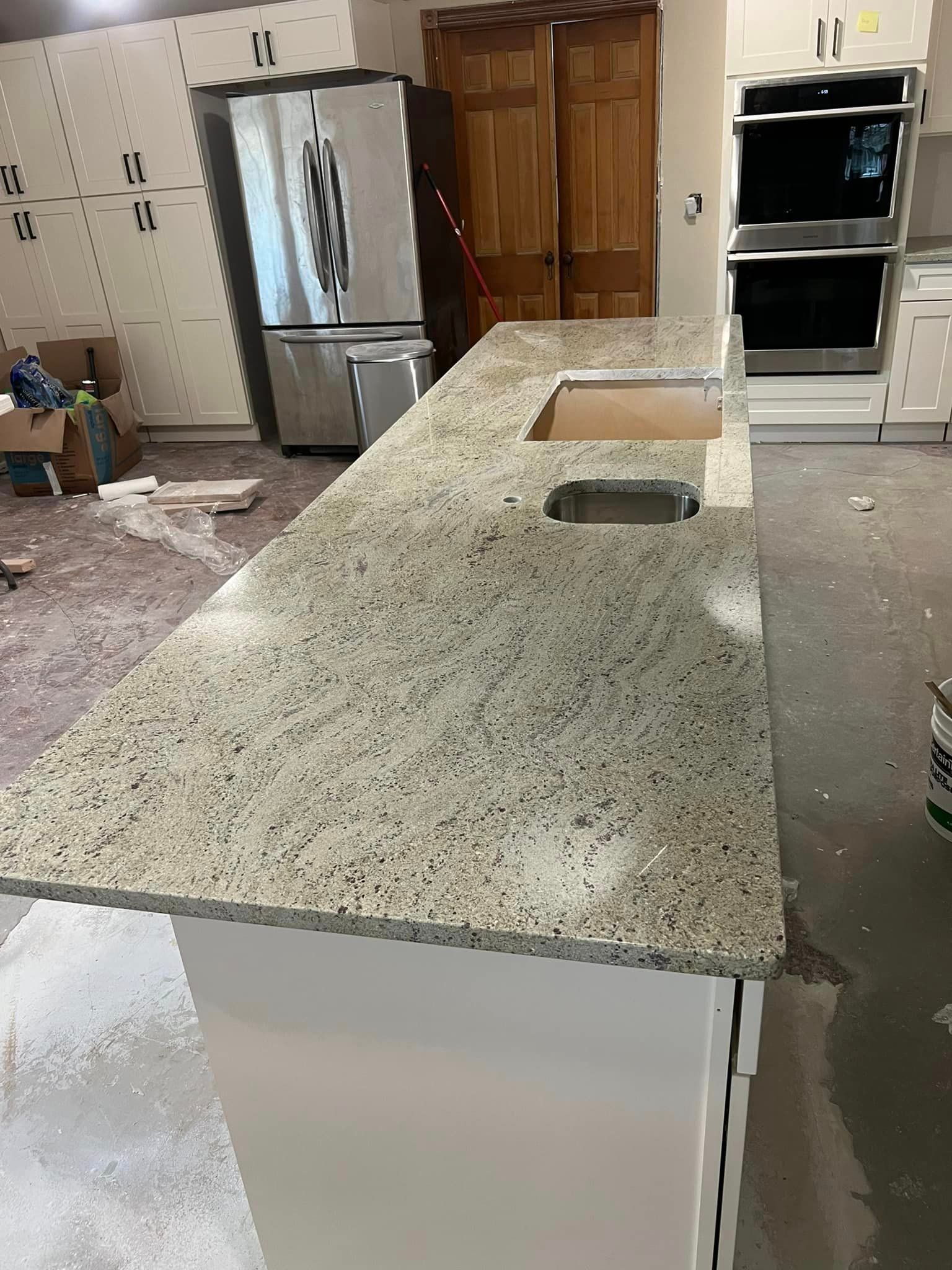 A kitchen with granite counter tops and stainless steel appliances.