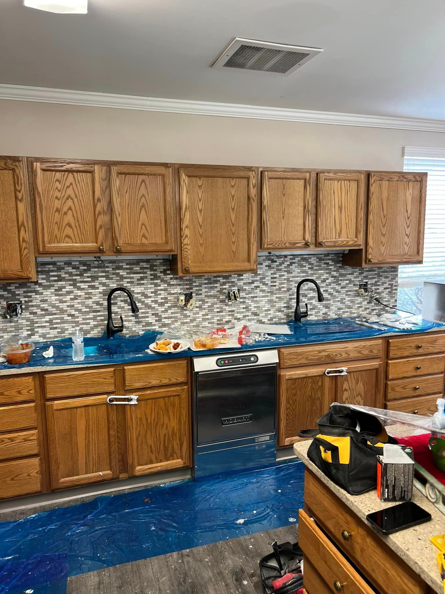 A kitchen with wooden cabinets and blue counter tops is being remodeled.