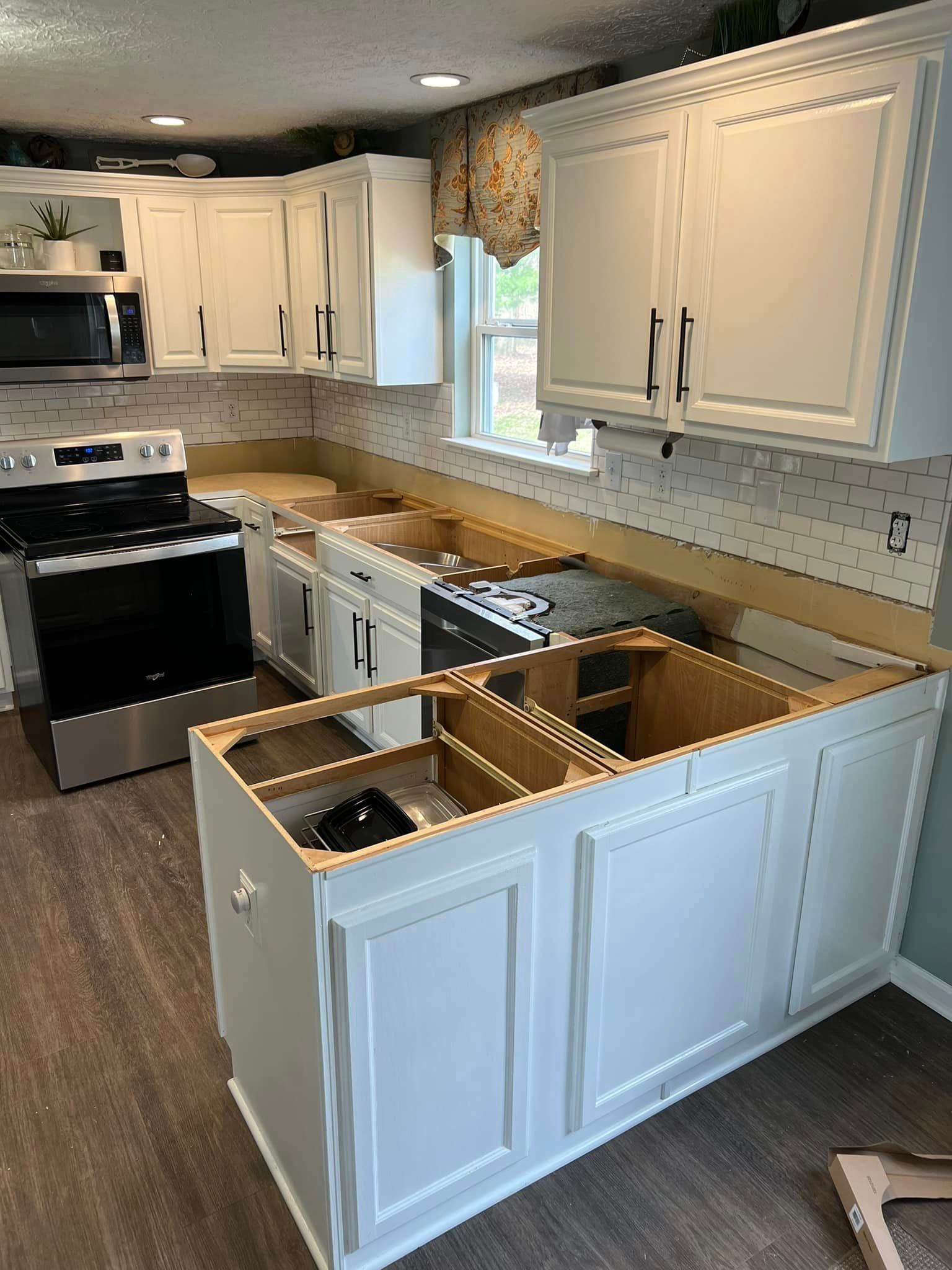 A kitchen with white cabinets and a stove.