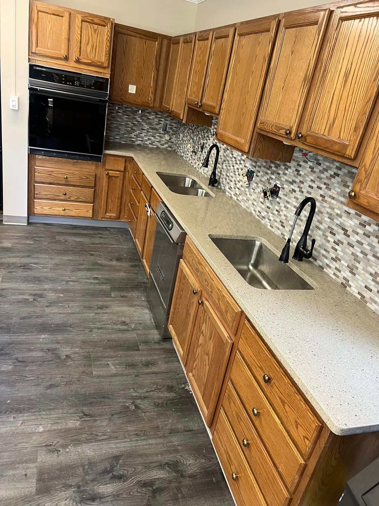 A kitchen with wooden cabinets , stainless steel appliances , and granite counter tops.