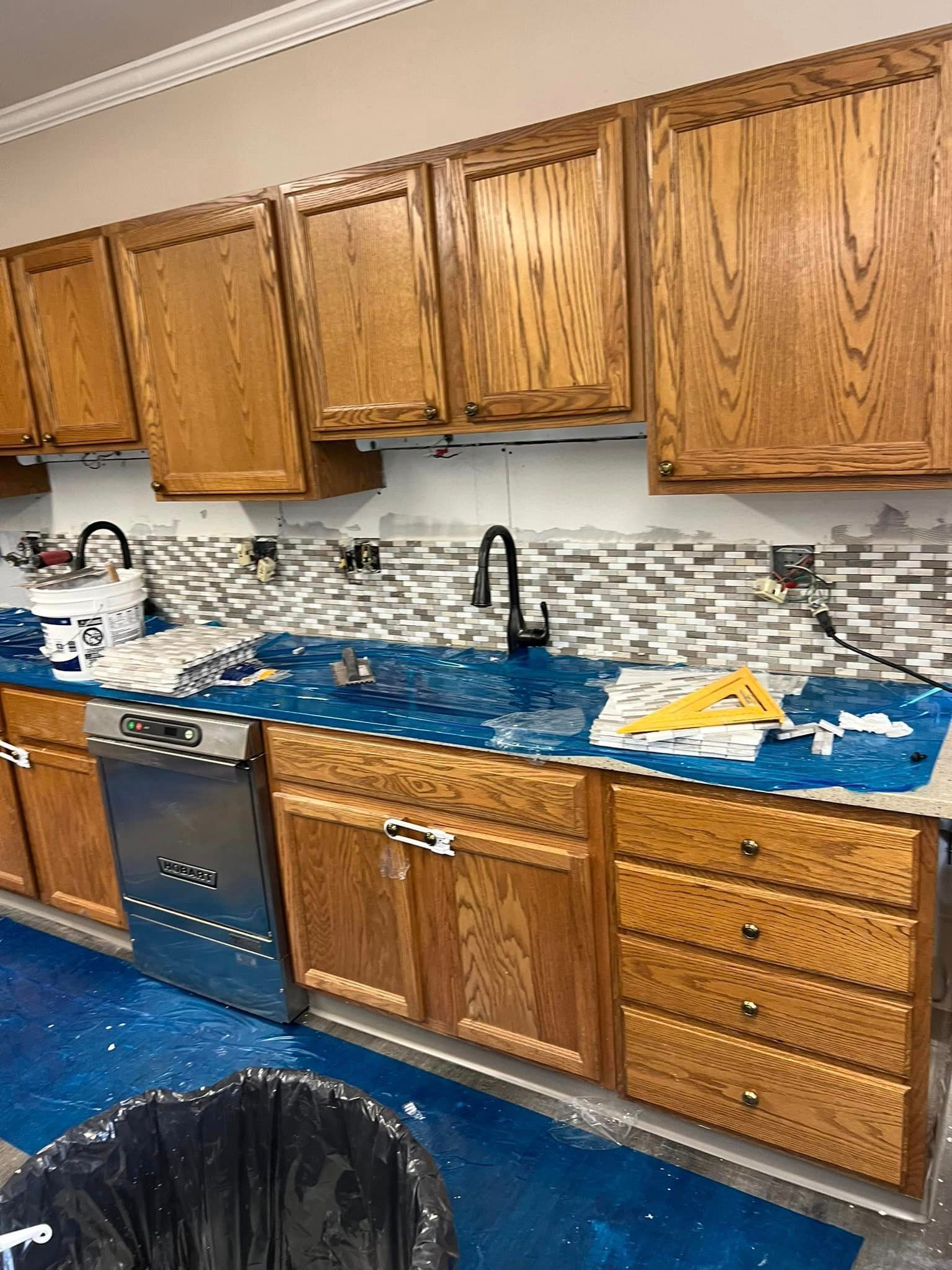 A kitchen with wooden cabinets and a stainless steel dishwasher.