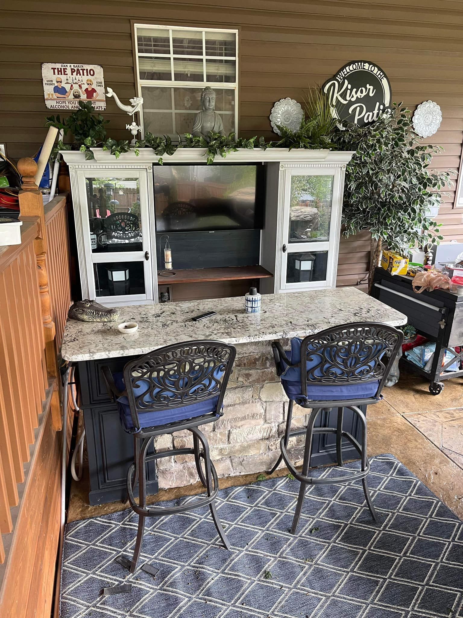 A patio with a table , chairs , and a television.