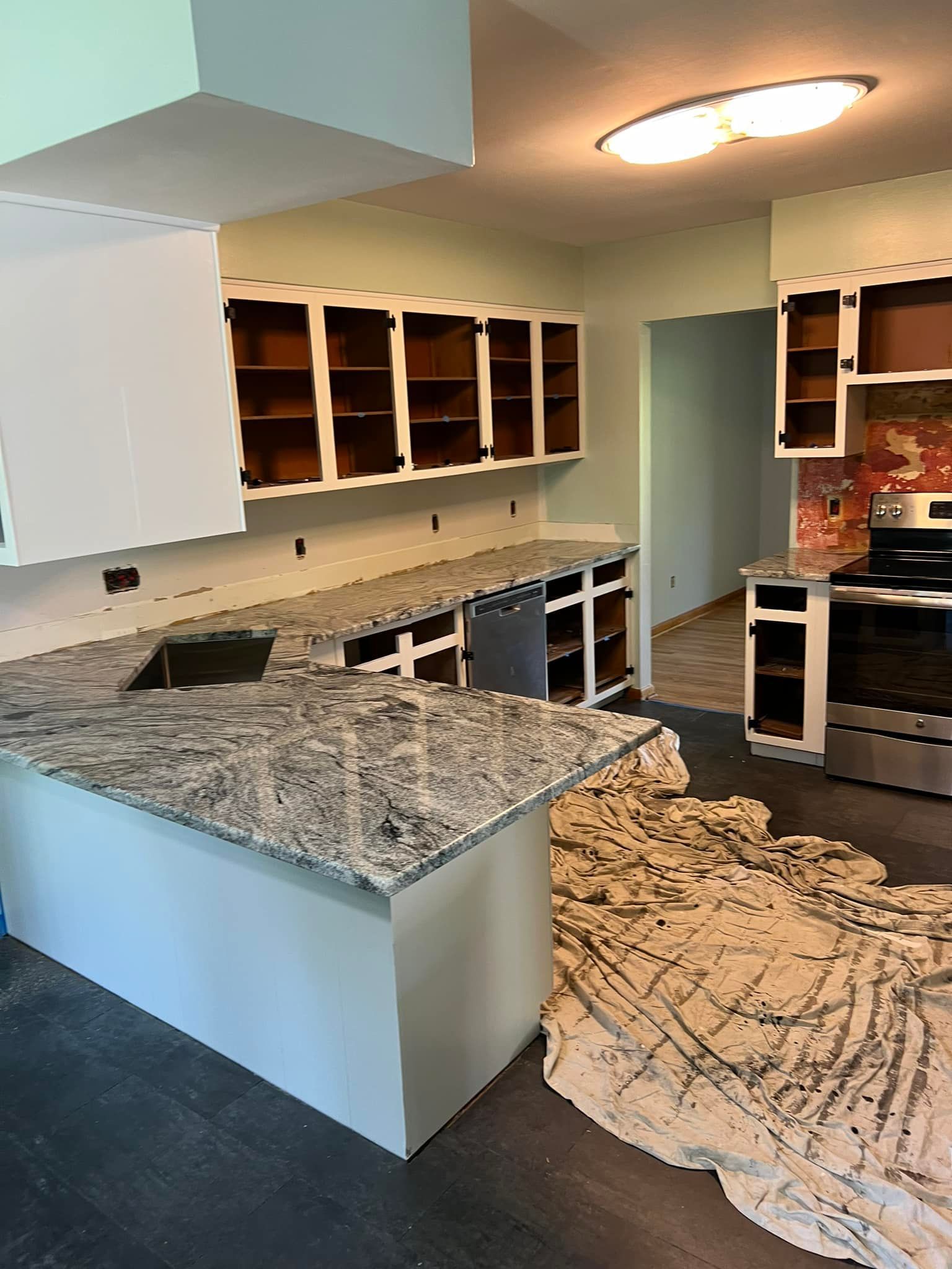 A kitchen with granite counter tops and stainless steel appliances is being remodeled.