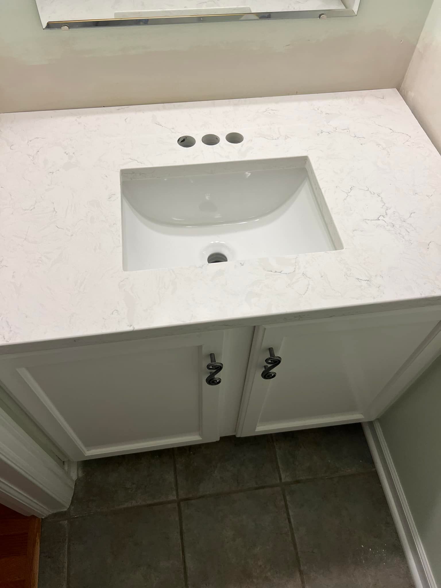 A bathroom sink with a white counter top and a mirror.