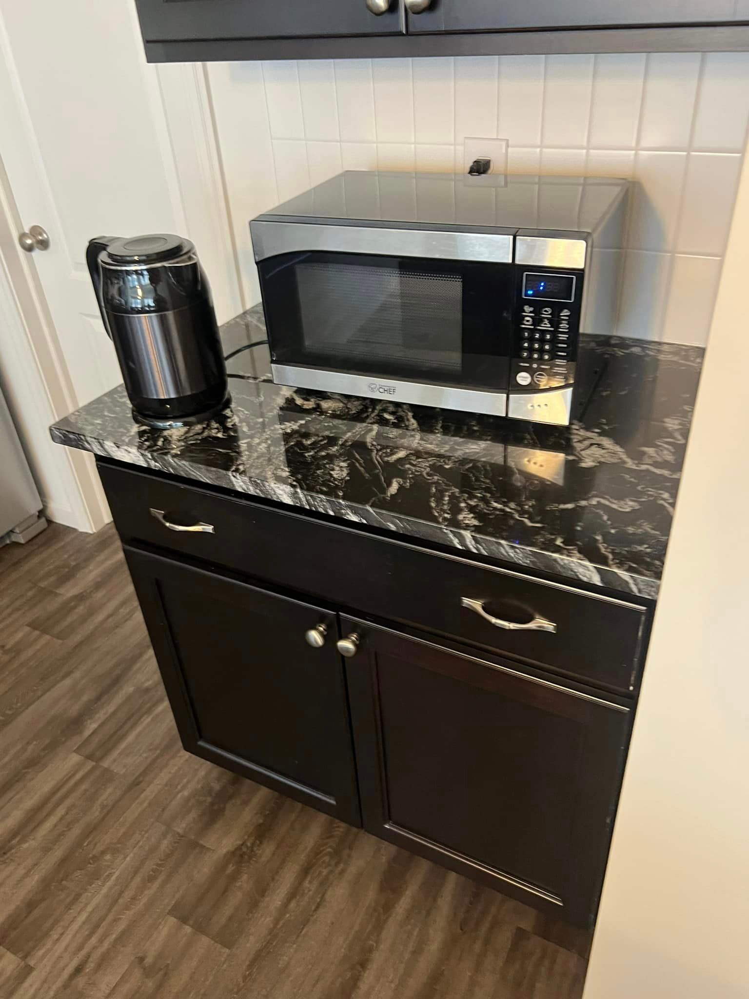 A microwave oven is sitting on top of a counter in a kitchen.