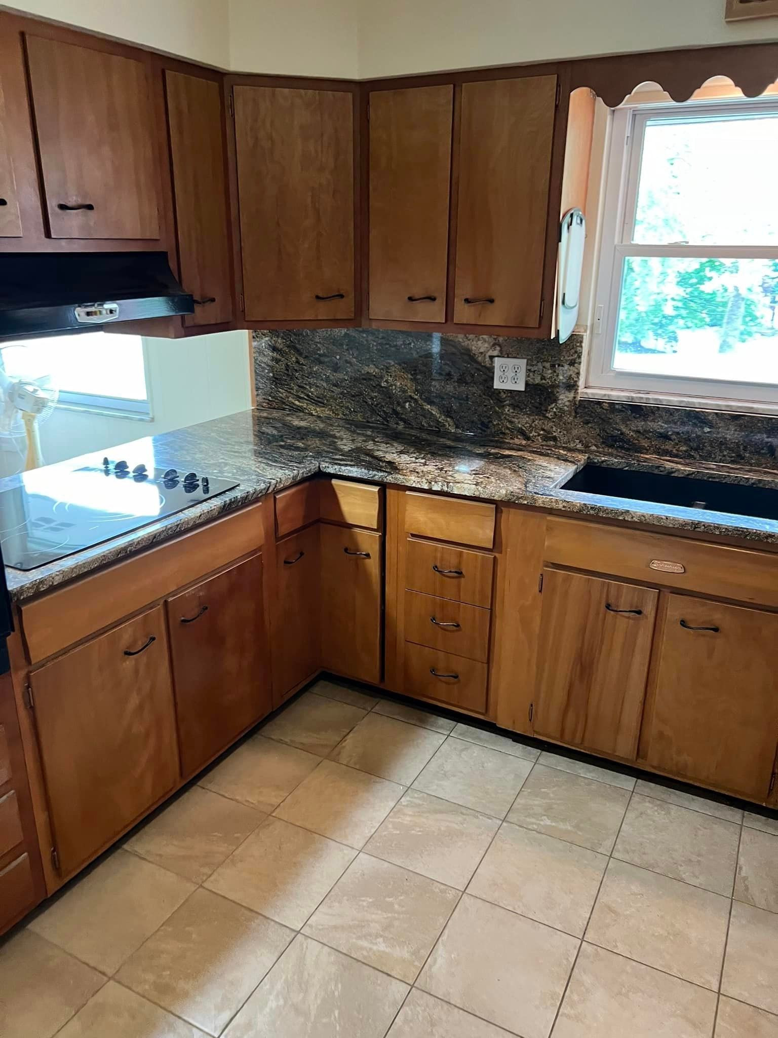 A kitchen with wooden cabinets and granite counter tops.