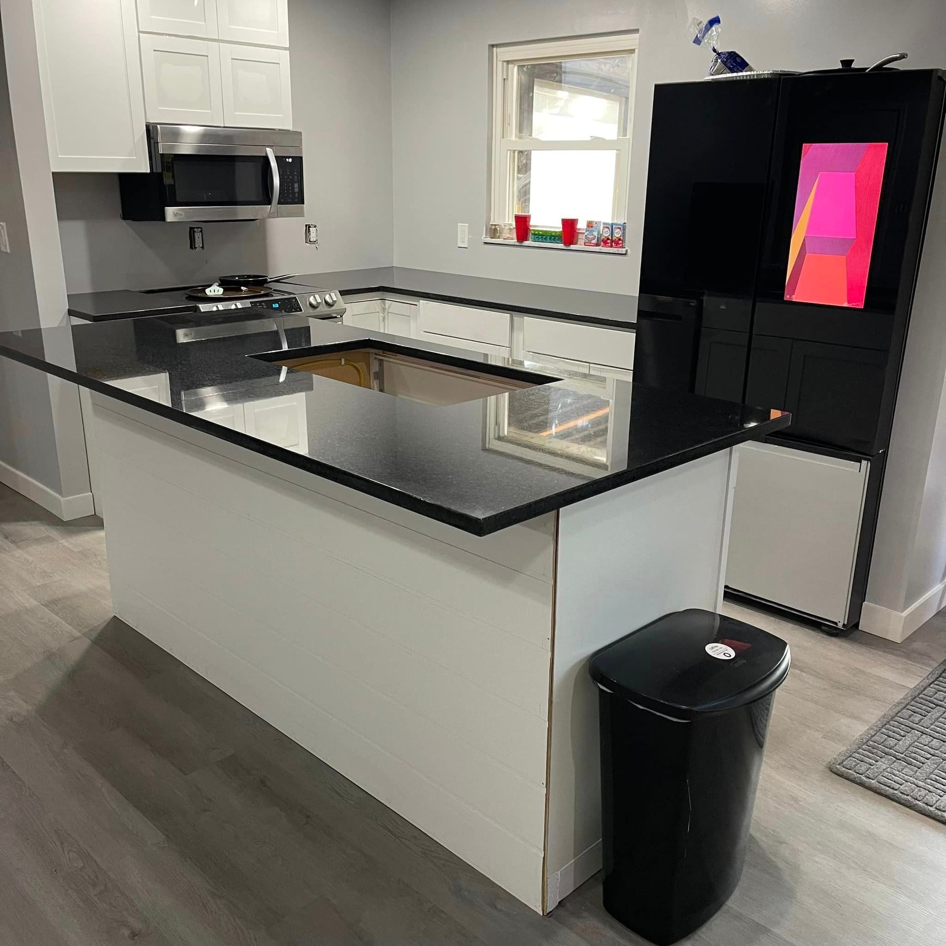 A kitchen with a large island and a trash can