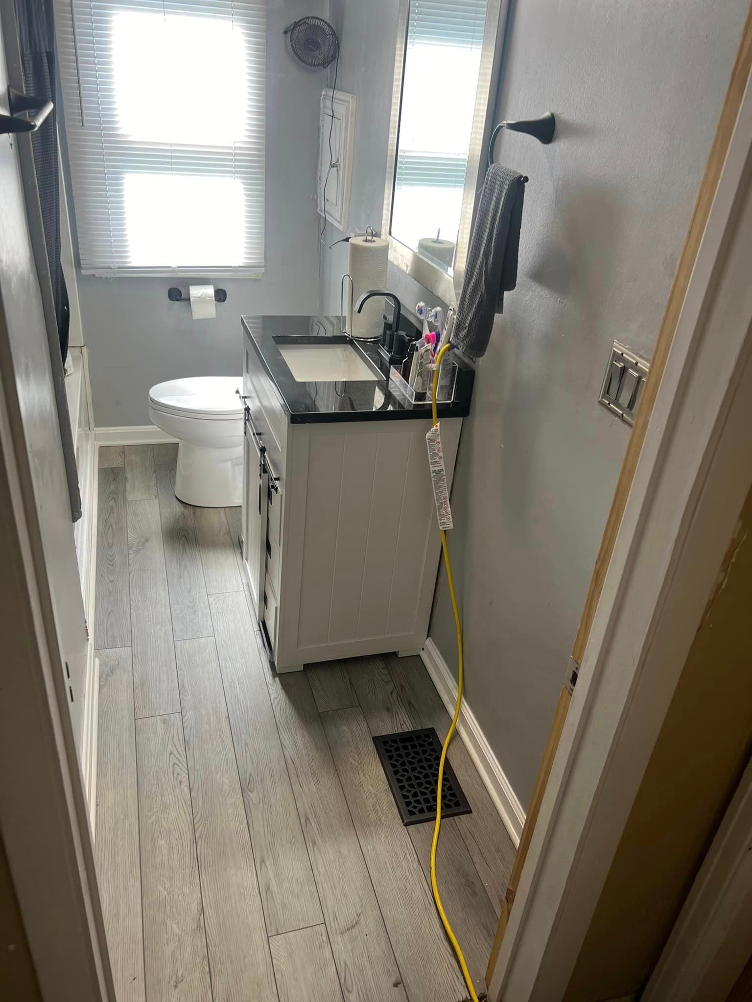 A bathroom with a sink , toilet and mirror.