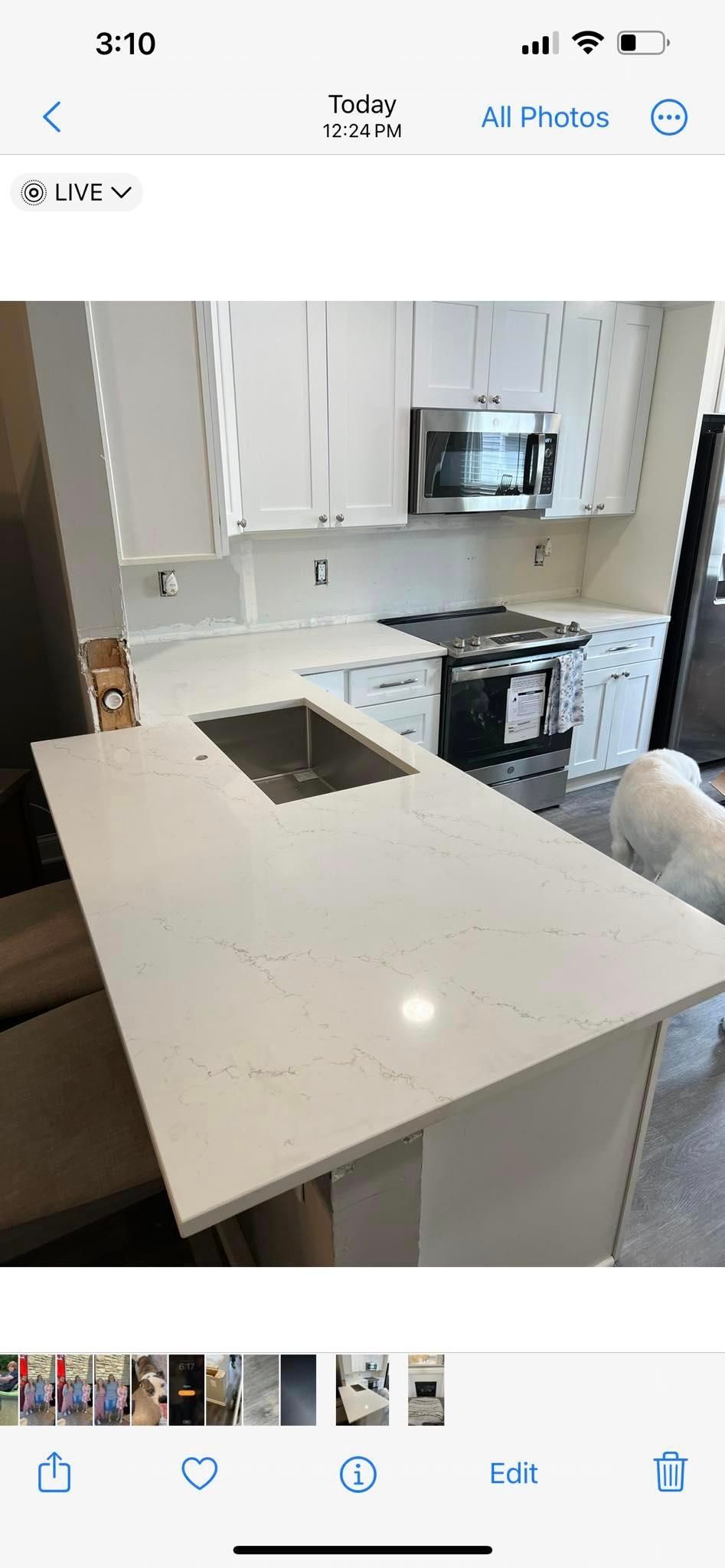 A kitchen with white cabinets , a sink , and a stove.