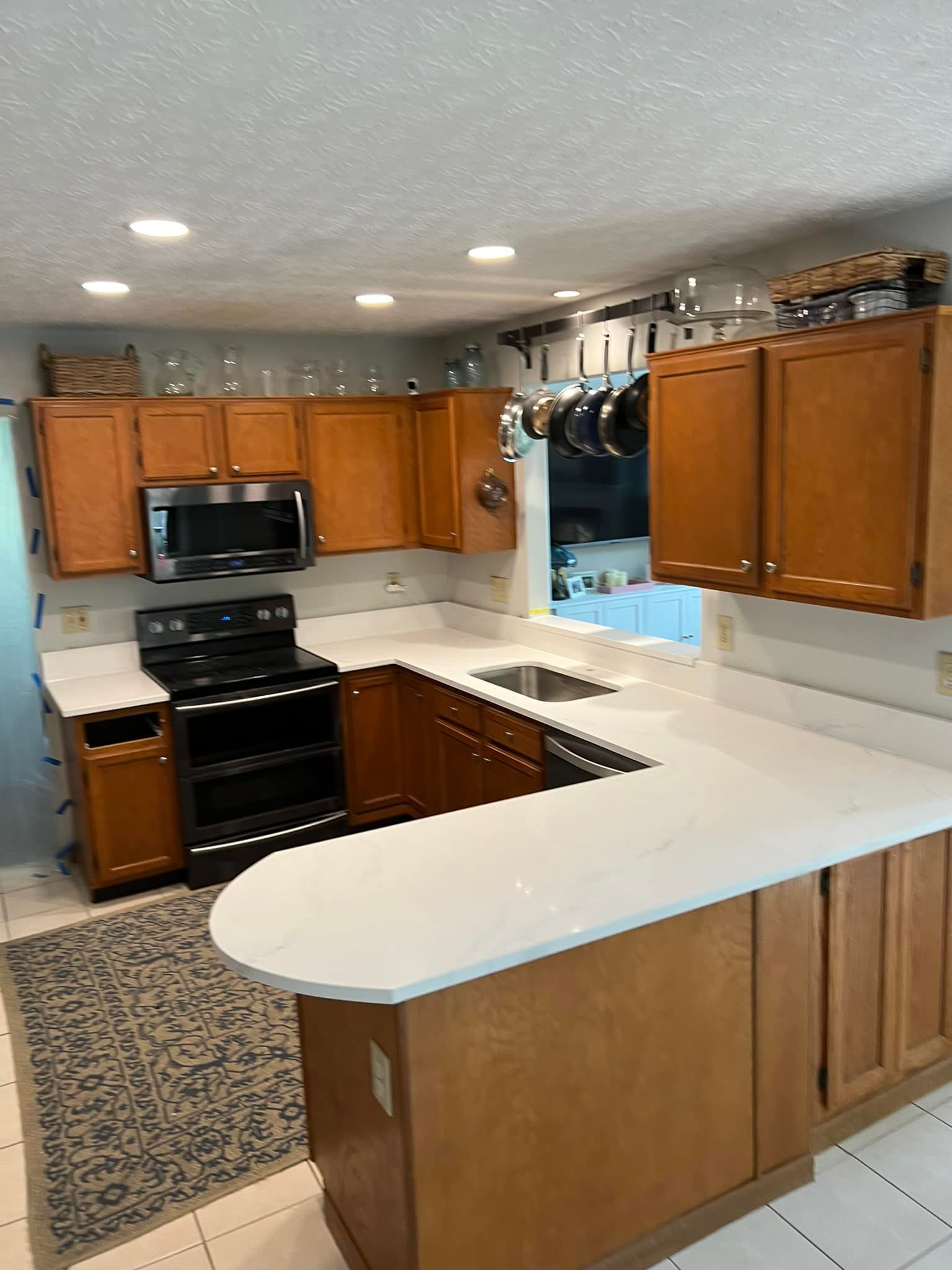 A kitchen with wooden cabinets and white counter tops