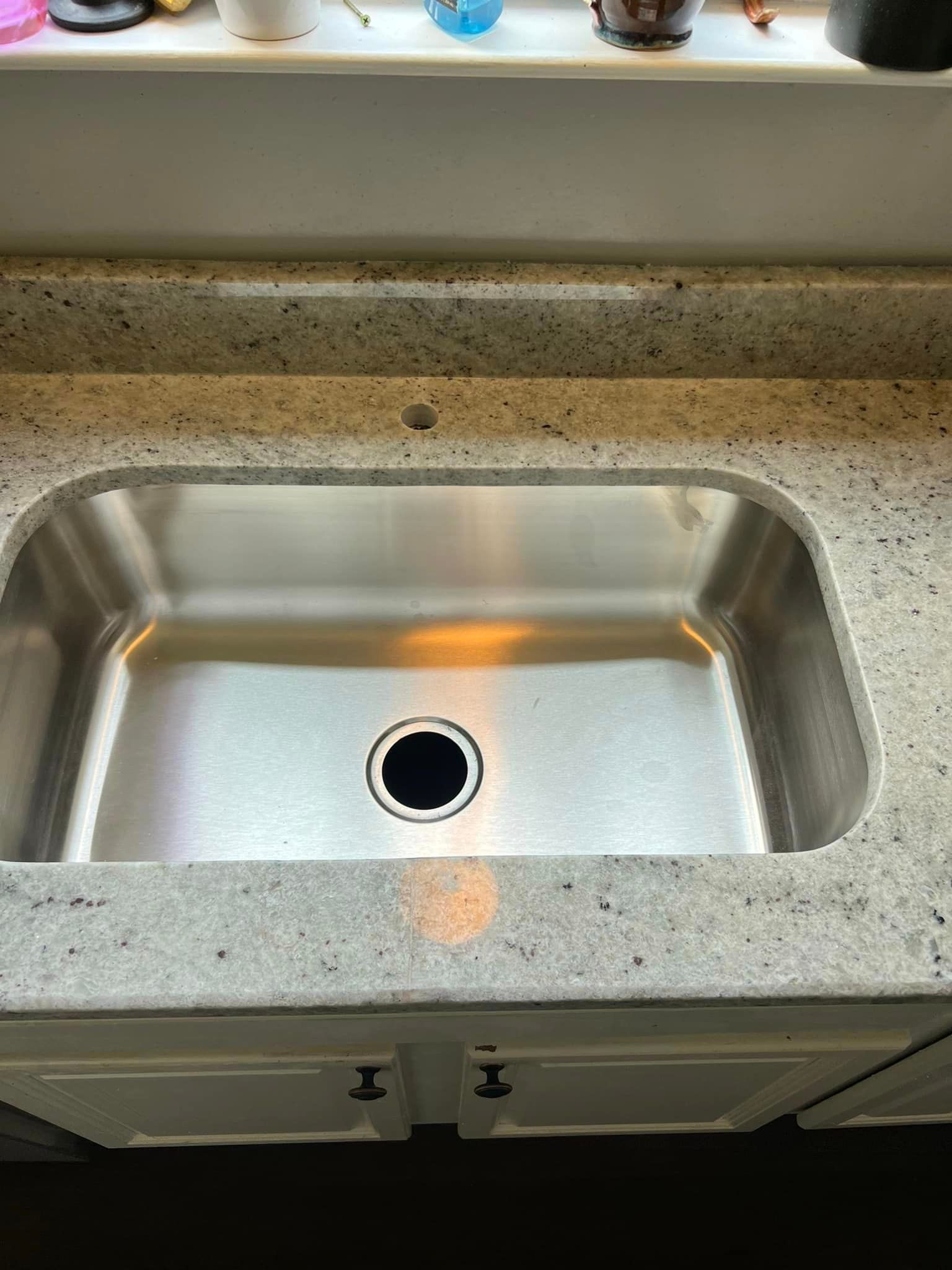 A stainless steel sink is sitting on top of a granite counter top.
