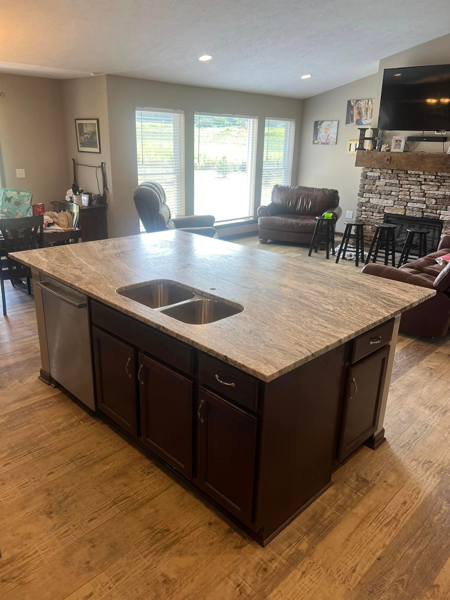 A kitchen with a large island and two sinks in a living room.
