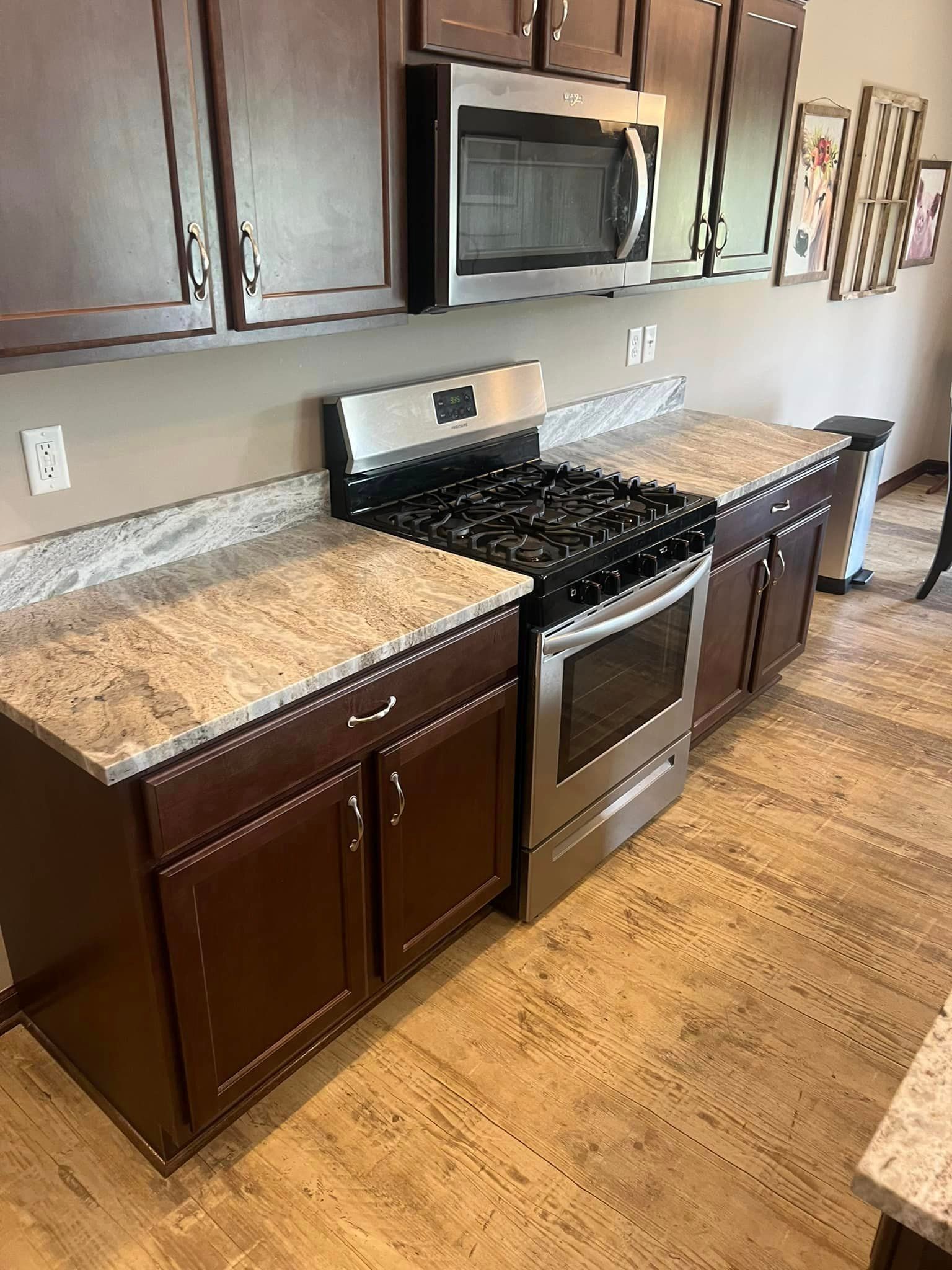 A kitchen with a stove , oven , microwave and granite counter tops.