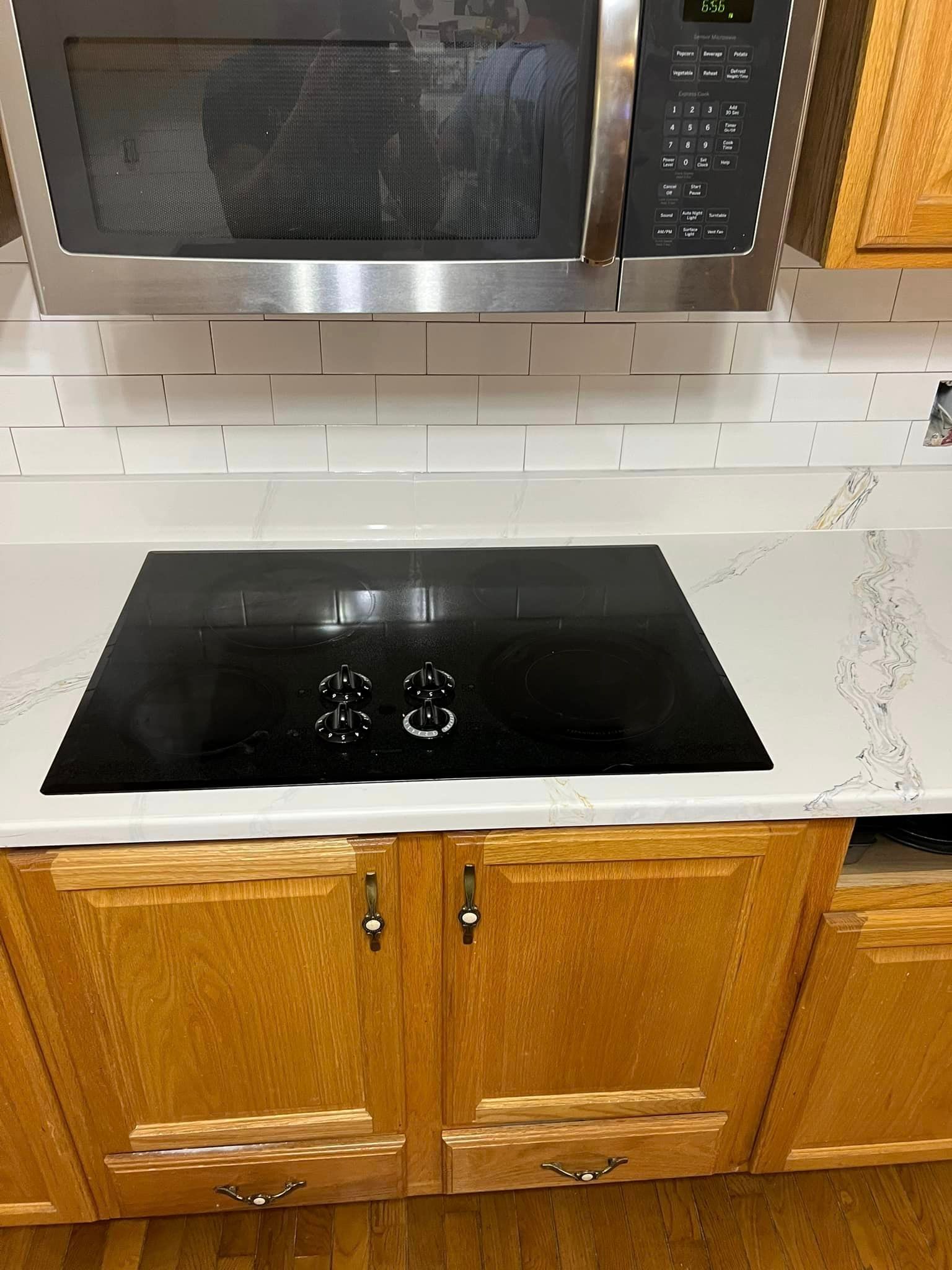 A kitchen with a black stove top oven and a microwave.