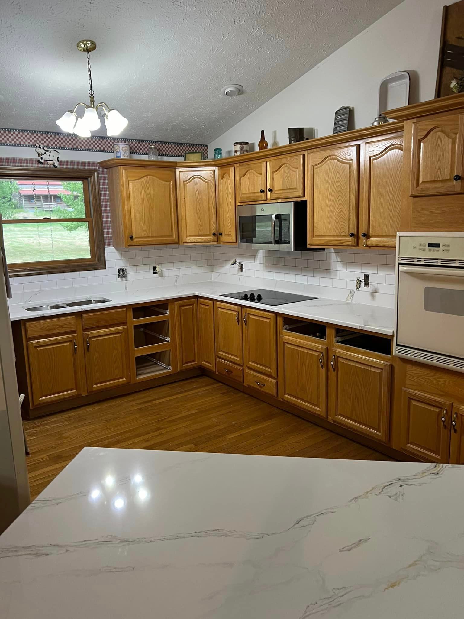 A kitchen with wooden cabinets and white counter tops