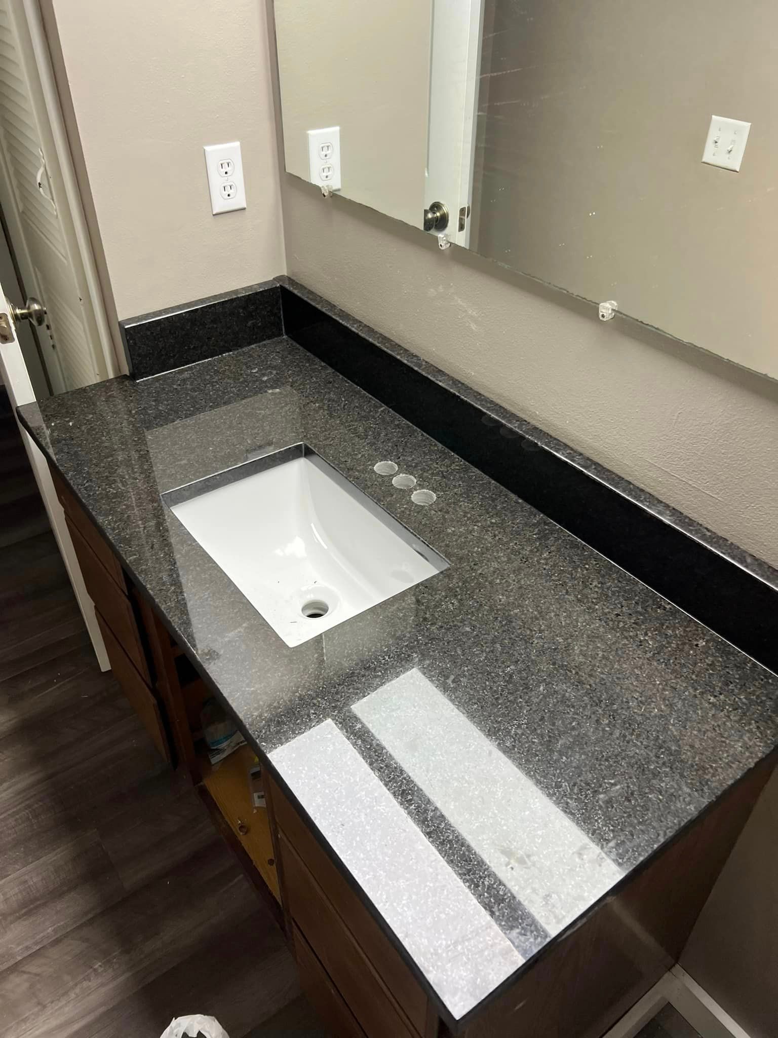 A bathroom vanity with a sink and a mirror.