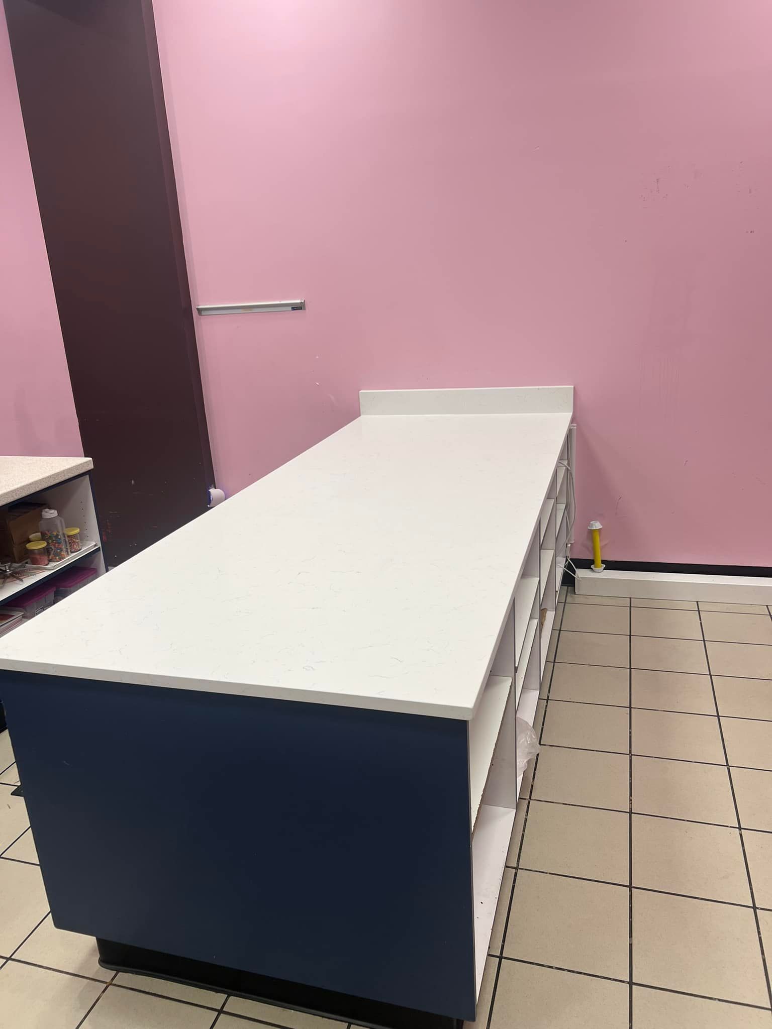 A long table in a room with a pink wall