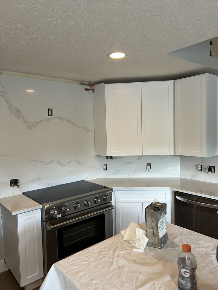A kitchen with white cabinets and a stove top oven