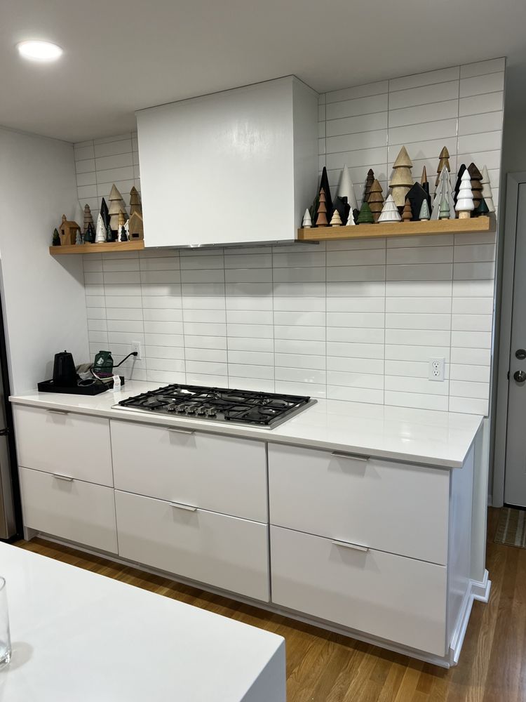A kitchen with white cabinets and a stove top oven.