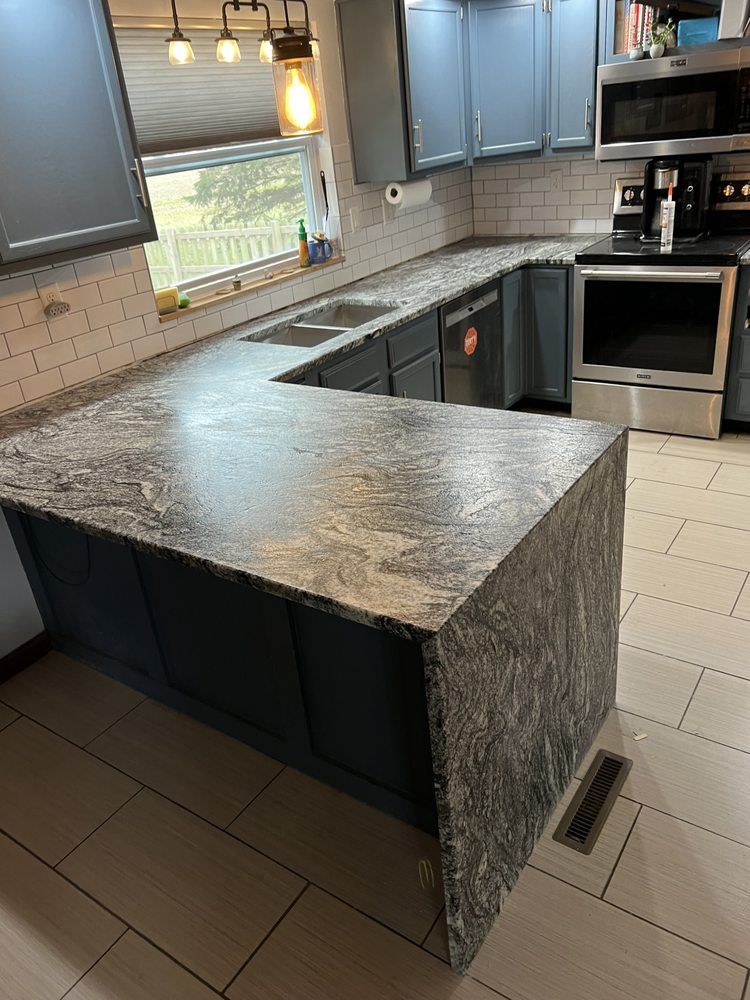 A kitchen with granite counter tops and stainless steel appliances.