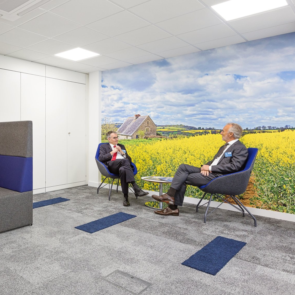 COlleagues chatting in front of biophilic print feature wall
