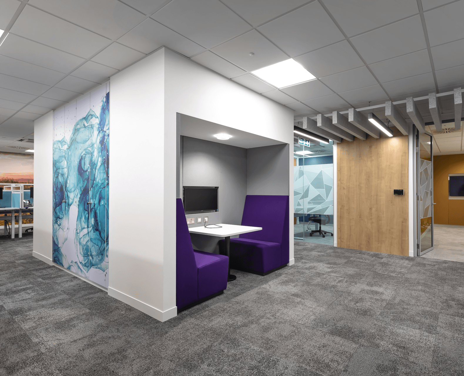 A room with purple benches and a table in it.