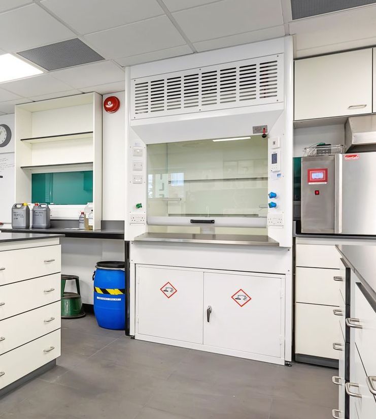 A kitchen with white cabinets and a stainless steel refrigerator