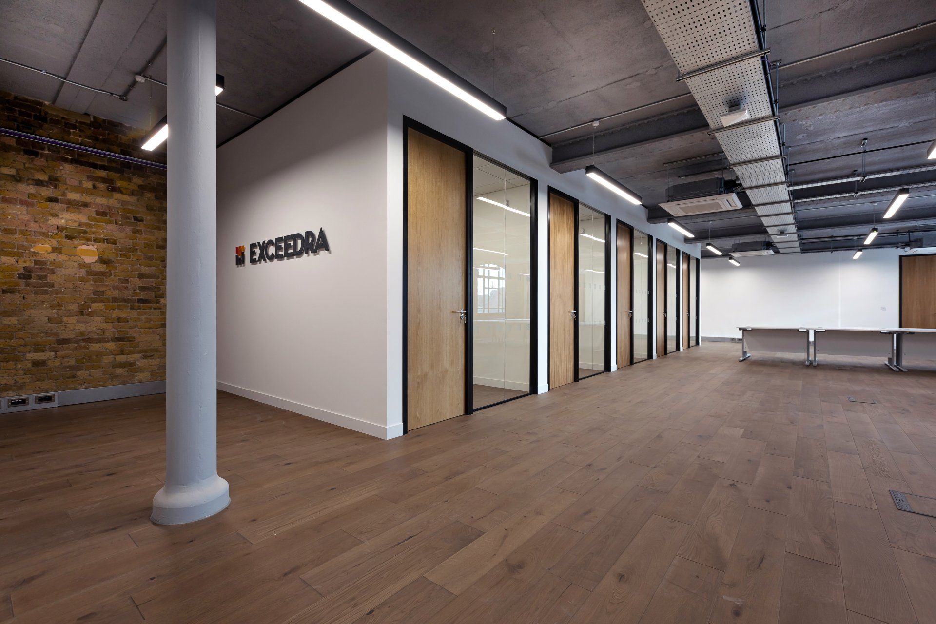 An empty room with a brick wall and a sign that says excelora