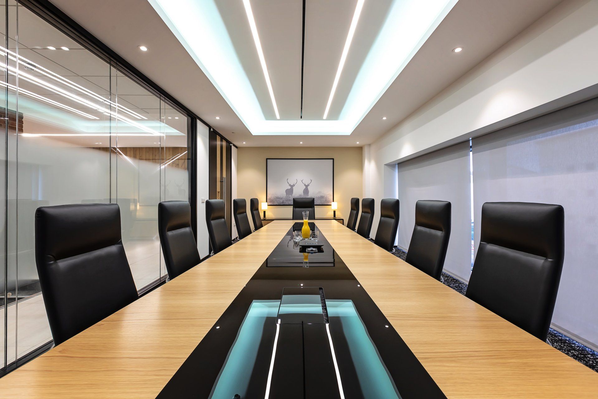 Large conference room table with overhead LED lighting