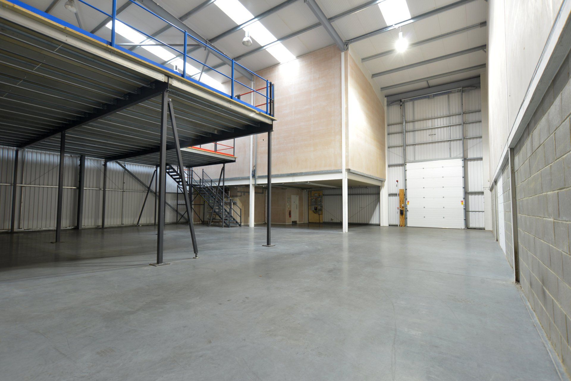 An empty warehouse with a mezzanine and stairs