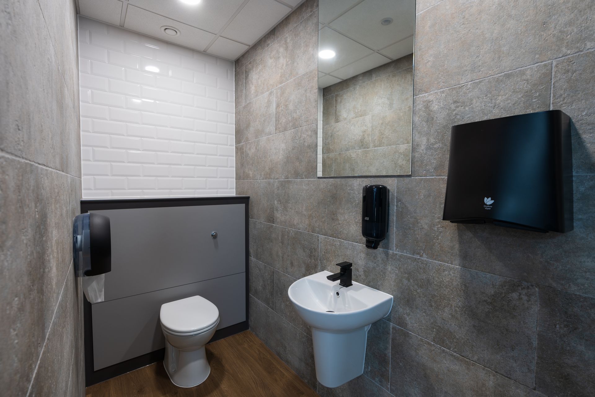 A room with a table and chairs and a flat screen tv on the wall.
