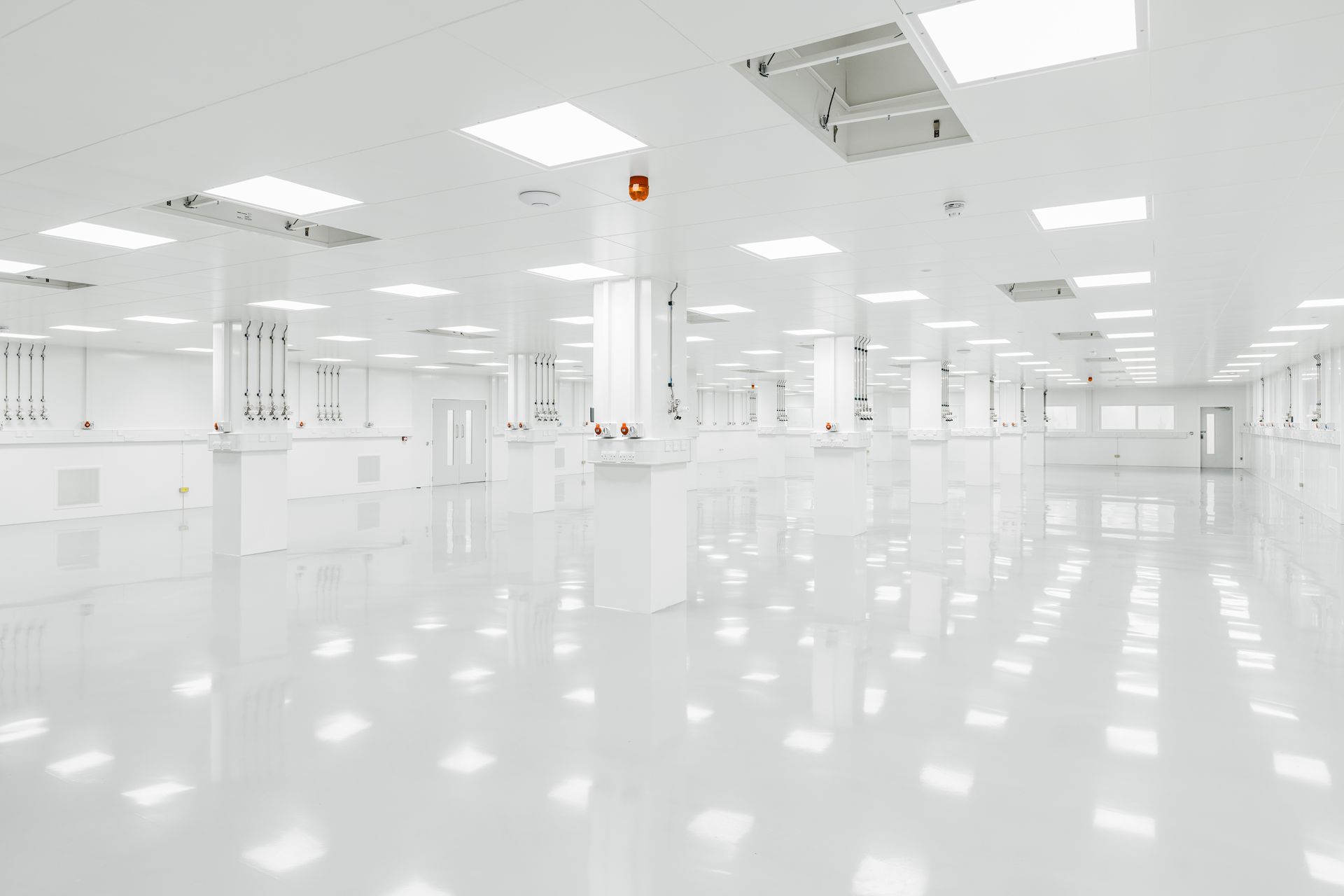 An empty clean room with white walls and floors in a factory.