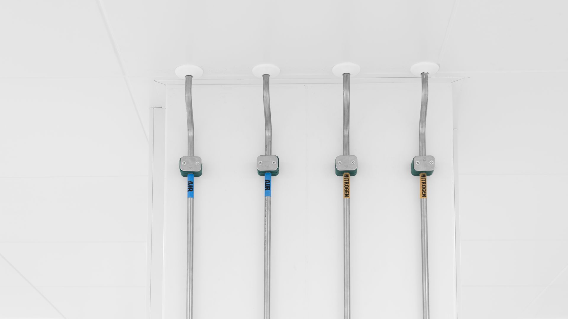 A row of pipes hanging from the ceiling of a building.