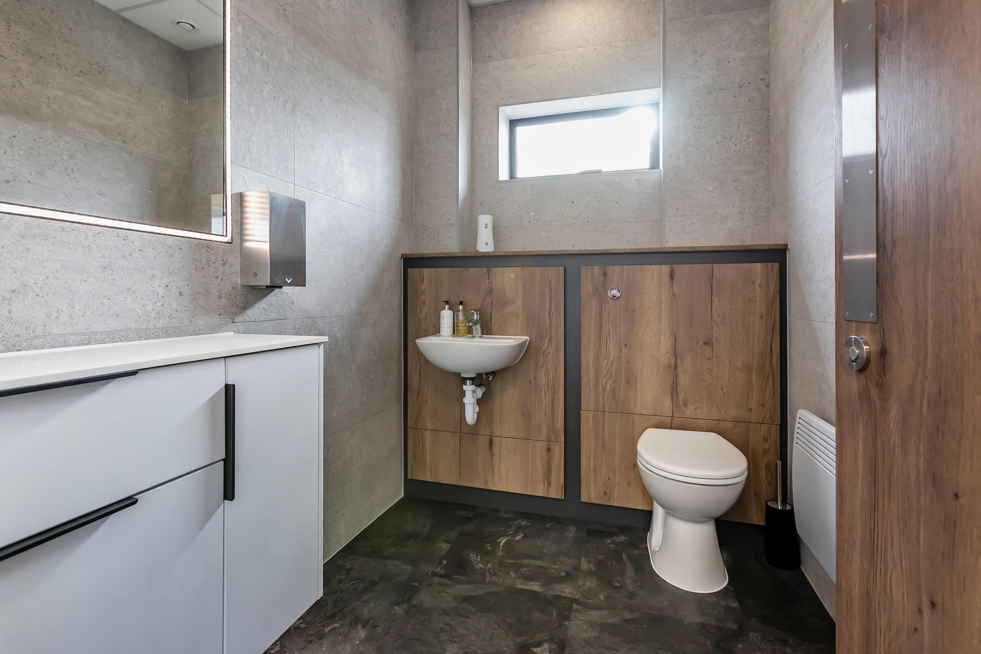 a bathroom with a toilet , sink and mirror .