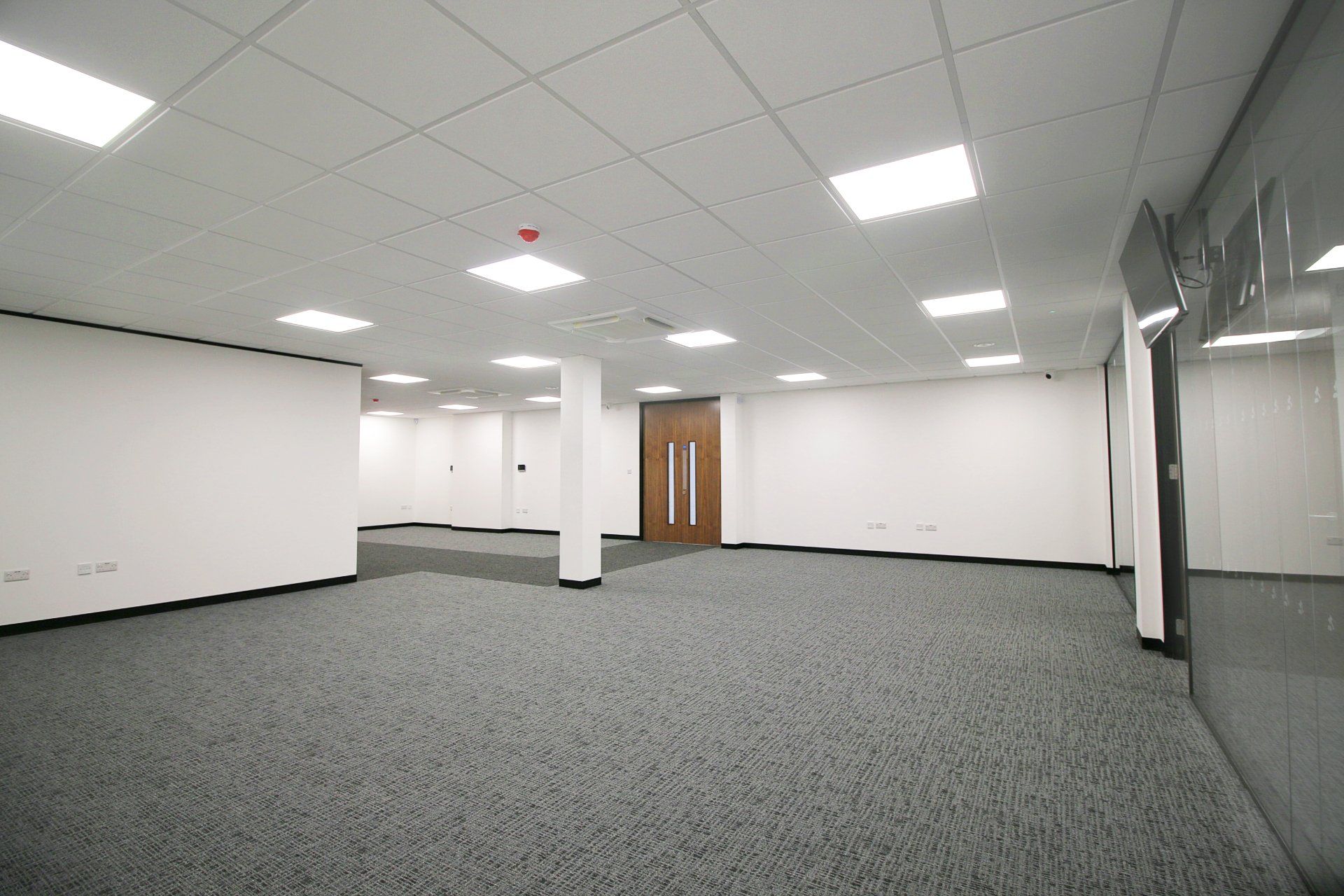 a large empty room with a carpeted floor and white walls .