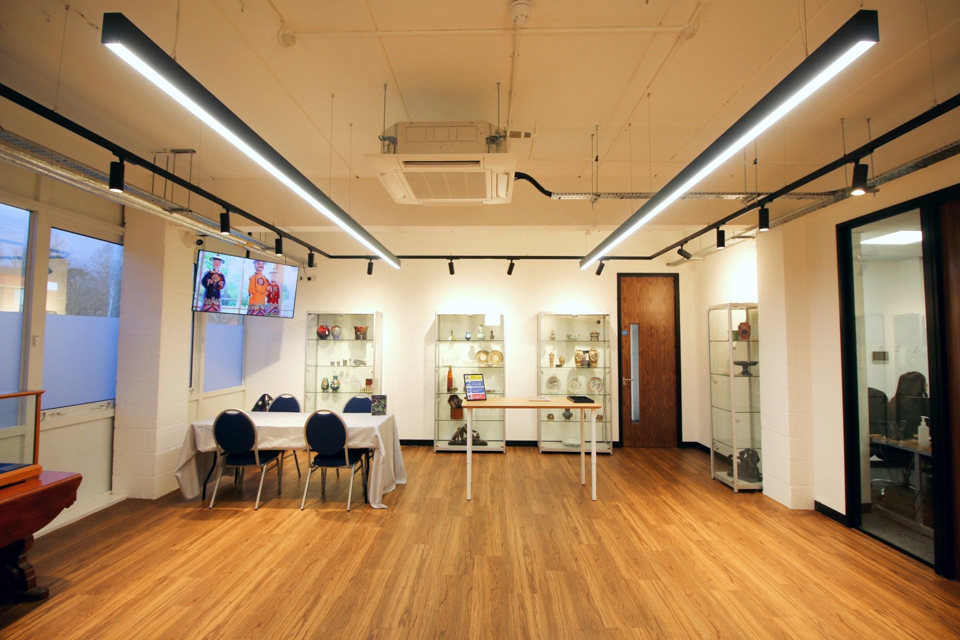 a large room with wooden floors and tables and chairs .