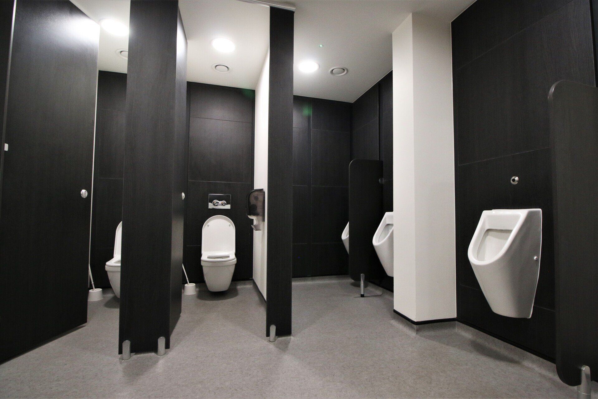 a row of toilets and urinals in a public restroom