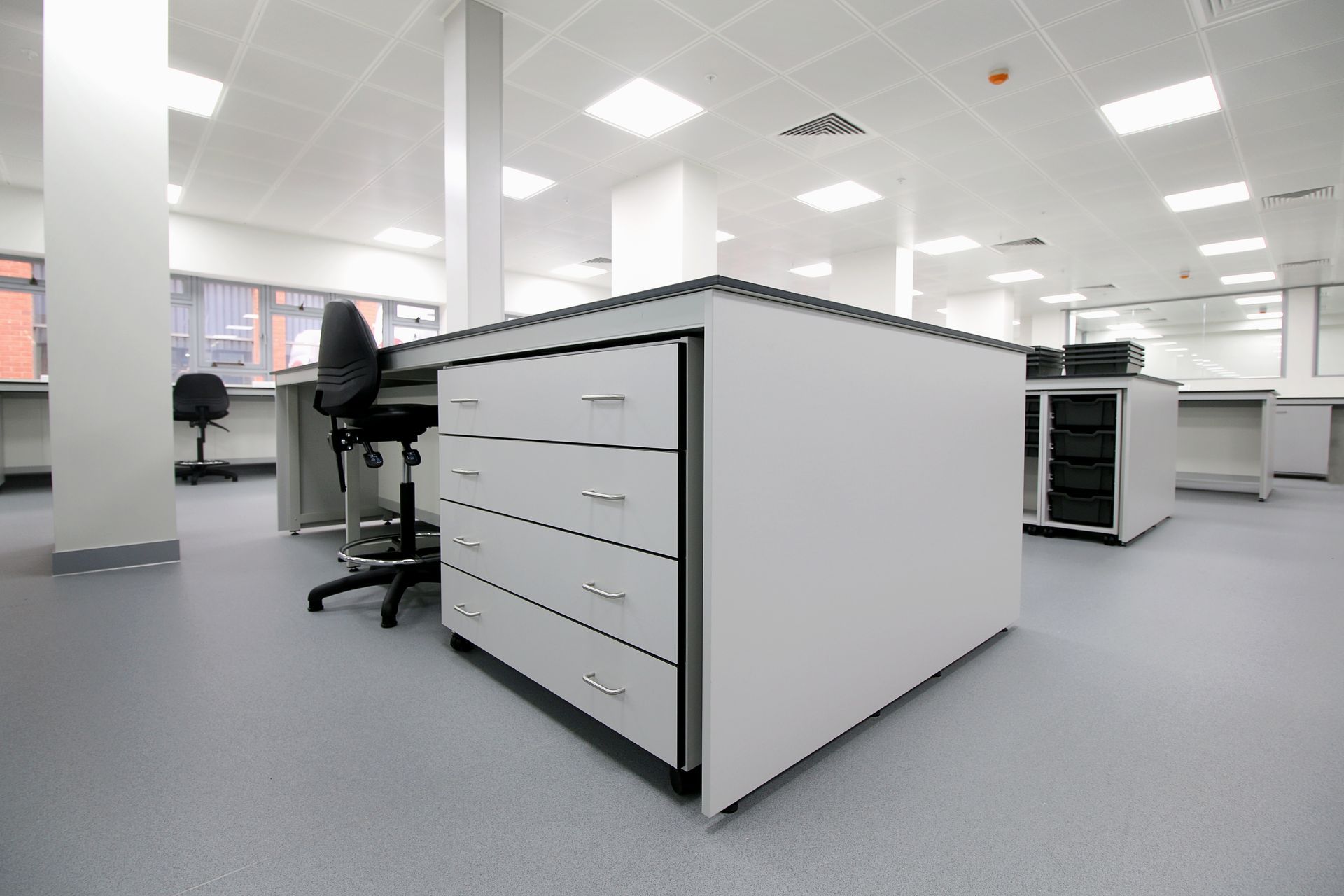 A large laboratory with a desk and chairs in it