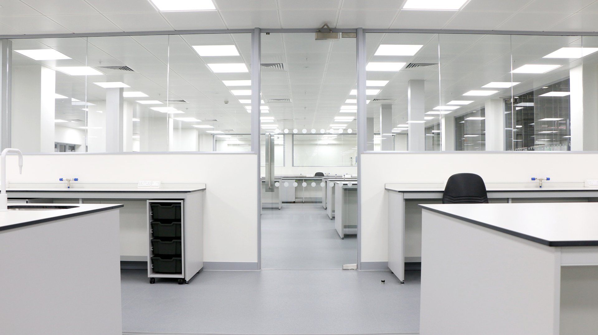 A large empty office with a lot of desks and chairs.