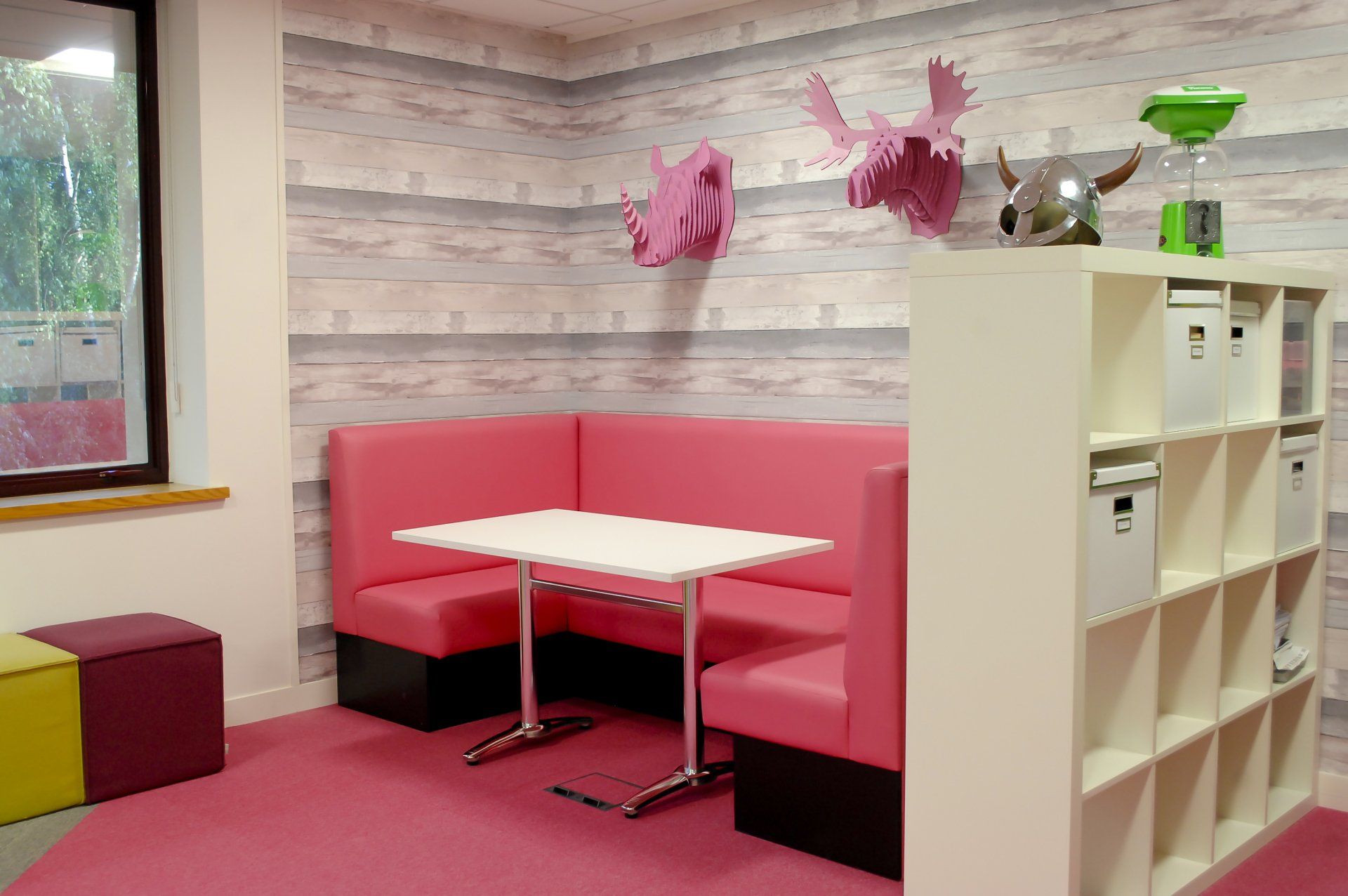 Corner breakout space with bright pink booth seating by Glenside
