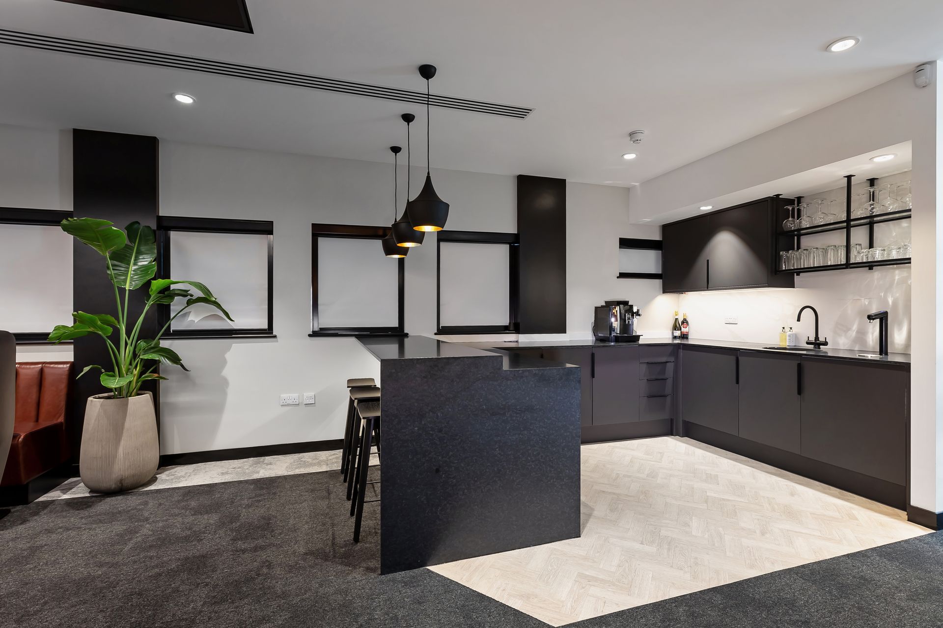 A kitchen with black cabinets and a large island in the middle of the room.
