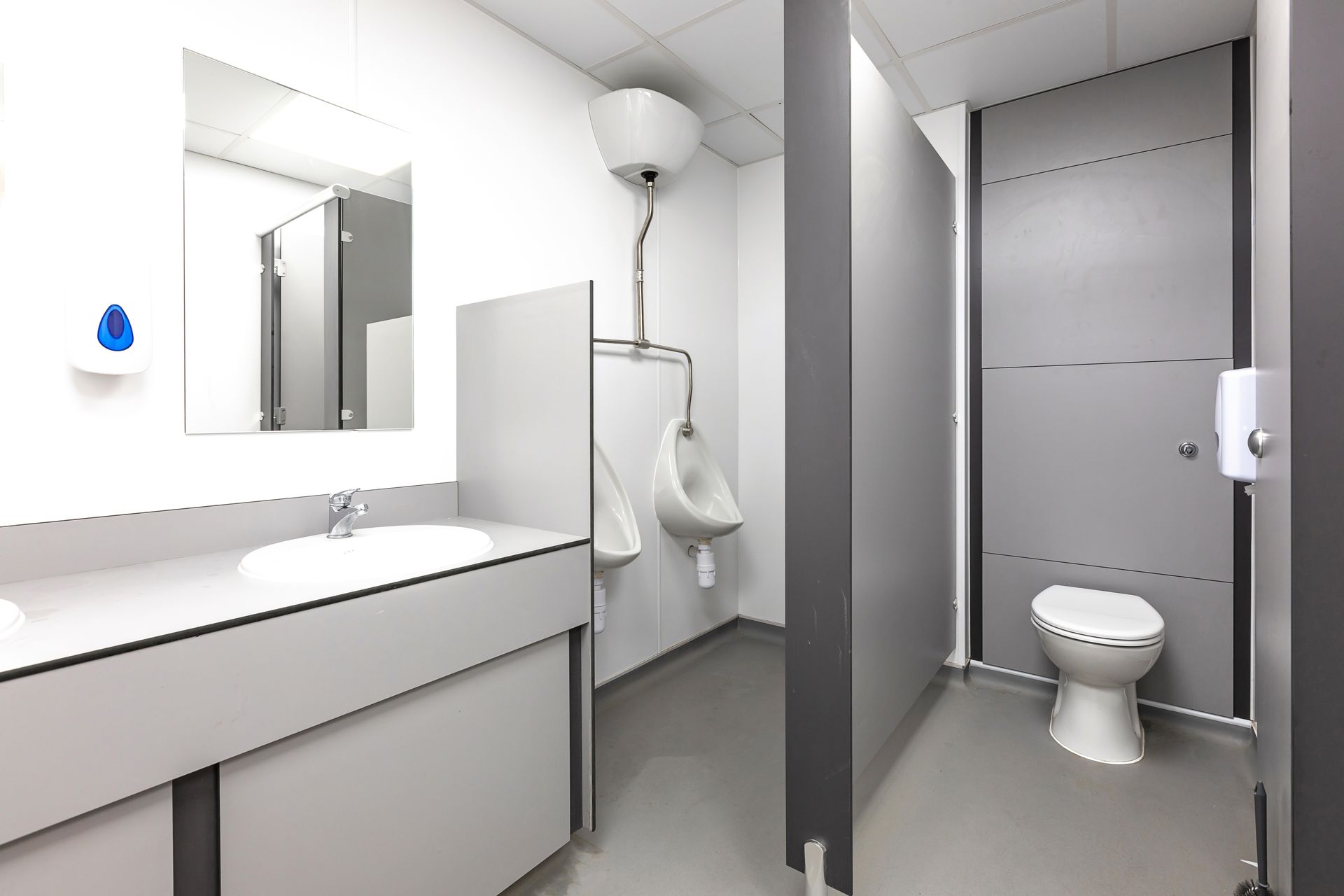 A bathroom with a toilet a urinal and a sink
